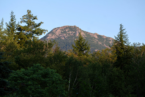 Mount Chocorua's summit rises above the trees on a 2023 New England summer morning in Tamworth New Hampshire.