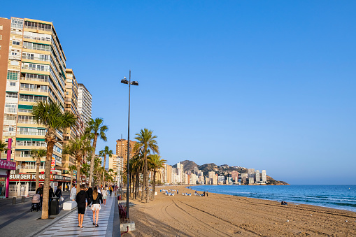 People strolling on the promenade overlooking the Levante Beach in Benidorm, a very popular tourist destination on the Costa Blanca