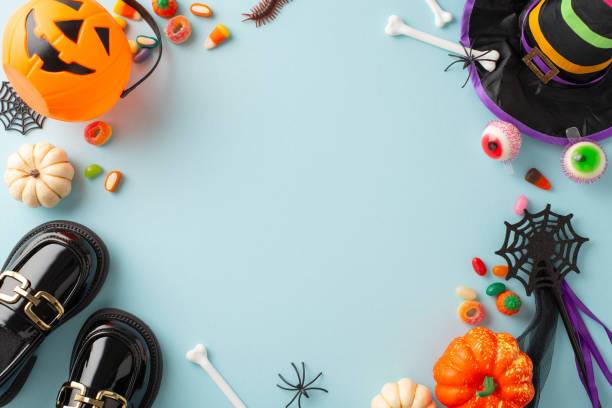 istock Kid-friendly Halloween celebration idea. Top-down view image showcasing sweets, youngster's costume components, and eerie decorations on a blue isolated surface, perfect for ads or text placement 1698846288