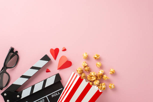 istock Enjoy a romantic movie date night with caramel popcorn, 3D glasses, paper hearts, and a clapperboard on a pretty pastel pink background 1698846292