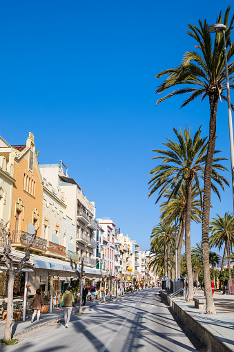 People strolling in the Paseo de la Ribera on the promenade of Sitges, a town belonging to Barcelona in Catalonia
