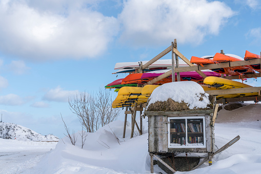 Mini library and canoes in winter, Sakrisoy in the Lofoten archipelago in Norway.