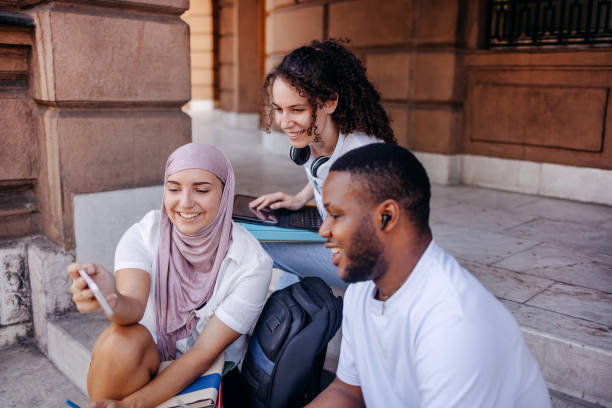 istock Multiracial group of college students having fun in front of university building while waching photos on mobile phone 1698866081