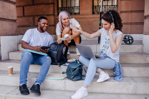 istock Multiracial group of college students having fun in front of university building while waching photos on mobile phone 1698866126