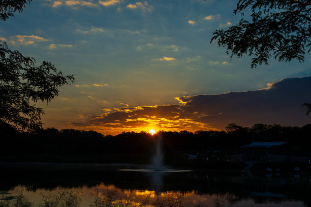 istock Sunrise light reflects on clouds and a pond. 1698875028