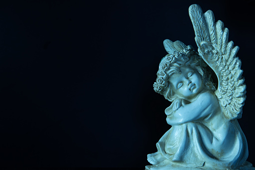 Photo of angel with copy space on dark background