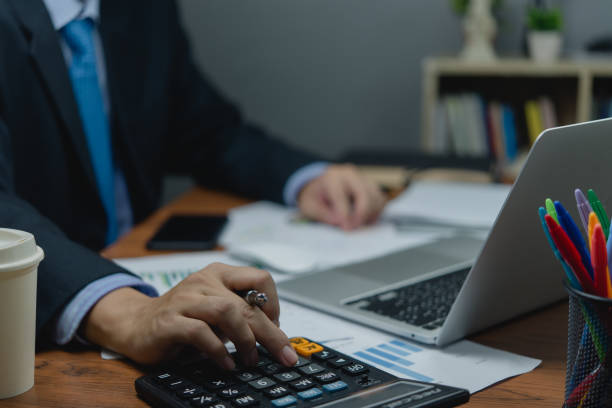 istock Businessman working on desk with calculator and document data with laptop computer. Business financial money account and tax fee concept. 1698902258