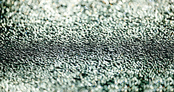 Abstract contrasting sparkling and sparkling droplets out of focus.