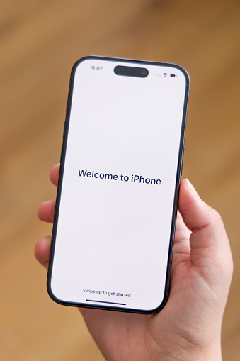 Mannheim, Germany - September 22, 2023. An Apple iPhone 15 Pro smartphone. Front view with welcome message. Space Black color version.