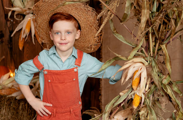 istock boy in orange overalls and straw hat harvesting pumpkins 1698922499