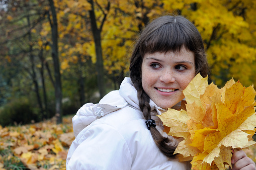 portrait of freckled teenage girl in the autumn park