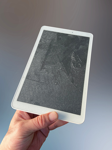 Dusty digital tablet, a hand holding dusty and dirty digital tablet with clipping path