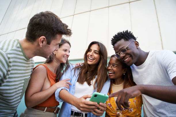 istock Diverse university students watching smartphones in college campus. 1698946932