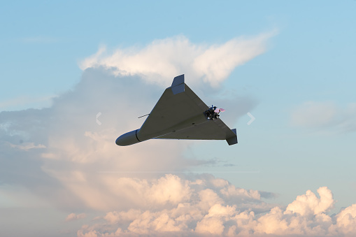 Russian army kamikaze combat drone in the sky against clouds, war in Ukraine, drone attack, 3d render.