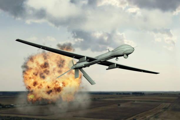 istock Combat attack drone dropping bombs, blowing up military facilities, flying in the clouds, aerial view, explosion of fire and smoke, war in Ukraine, Armenia, 3d render. 1699012782
