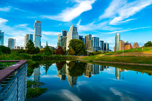 gorgeous sunny afternoon with mirrored Lake Reflections of Austin Texas Cityscape and modern skyscrapers with green nature pond