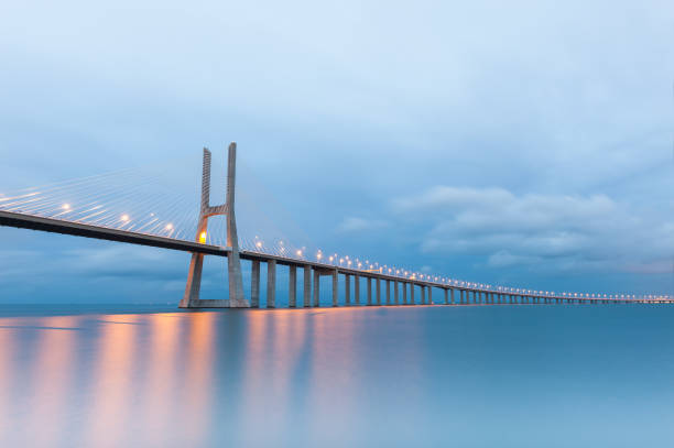 Vasco da Gama suspension bridge with lights at sunset in Lisbon, Portugal. stock photo