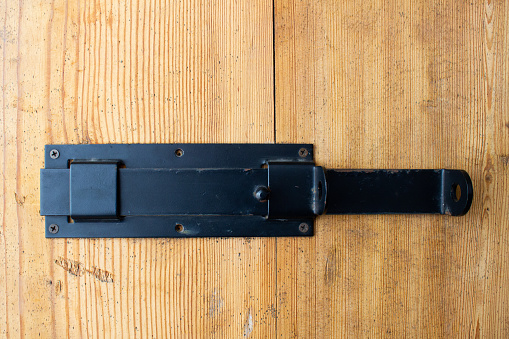 Metal latch, latch on the door. Iron lock on a wooden door.