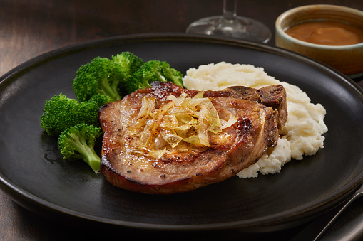 Grilled Bone In Pork Chop with Mashed Potatoes, Broccoli, Fried Onions and Gravy