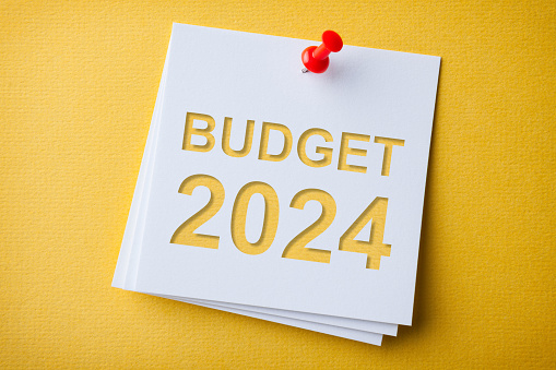 Budget 2024 Word in White Sticky Note on Blue Chardboard Background