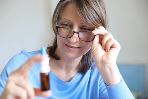 istock Middle-aged woman shows nose drops in her hand 1699081615