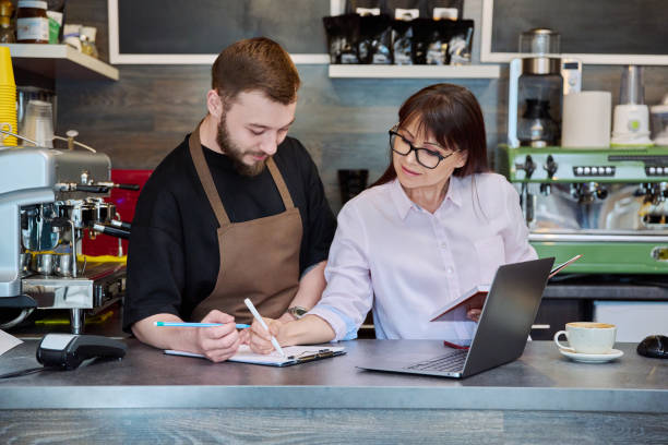 istock Team male and woman talking, working, using laptop, coffee shop 1699081725