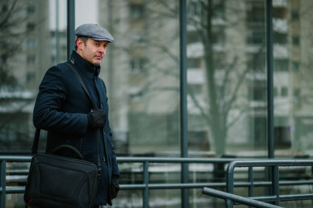 istock An elegant businessman is going to work in rainy cold weather. 1699088931
