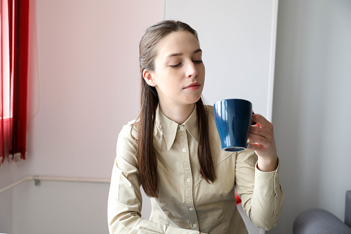 young business woman with a cup of coffee on a break in the office. Business concept.