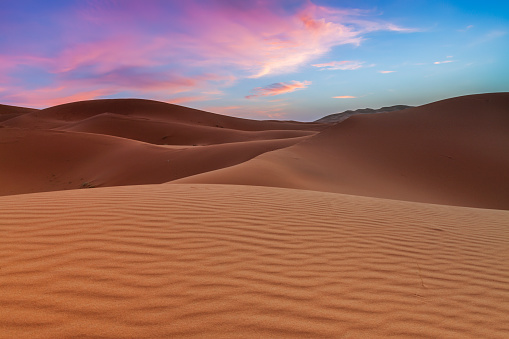 Sunrise over sand dunes, Western Sahara Desert in Morocco, part of Sahara Desert. The Sahara Desert is the world's largest hot desert.