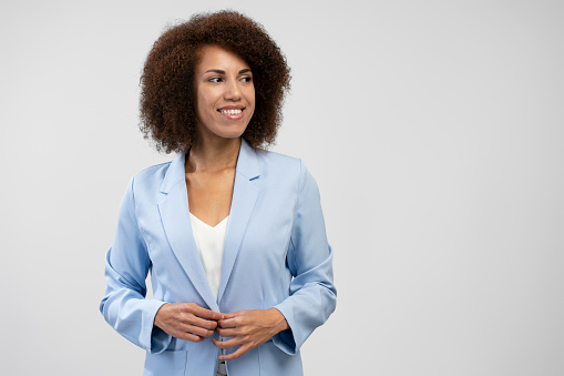 Portrait of smiling African American businesswoman wearing stylish suit looking away isolated on background. Successful business concept