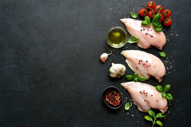 istock Raw chicken fillet with ingredients for making . Top view with copy space. 1699143153