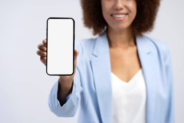 istock African American woman holding mobile phone showing empty display, selective focus 1699143155