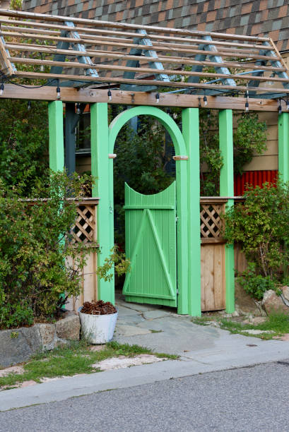 Old fashioned bright green garden gate with long trellis