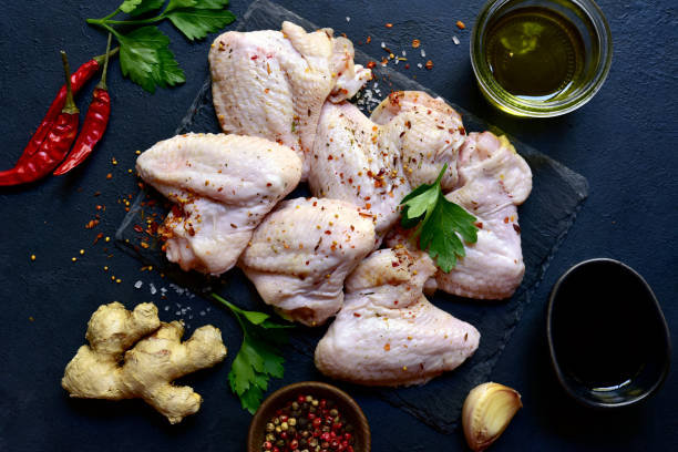 istock Raw chicken wings with ingredients for making. Top view with copy space. 1699156930