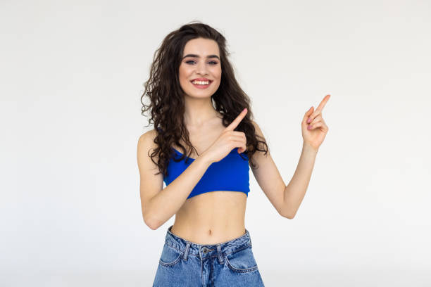 istock Smiling woman pointing finger side isolated portrait on white. 1699186324