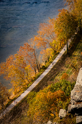 Harpers Ferry National Park, WV, USA-Autumn lakeside country road in the forest with golden foliage