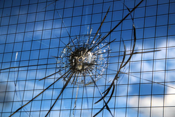 Bullet hole in a broken bulletproof glass, closeup image