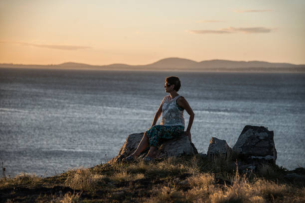 Free Stock Photo of Person Sitting on Rock Looking Out at Ocean ...