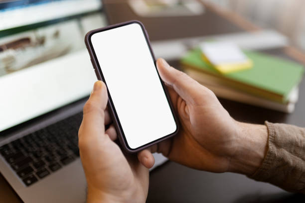 istock Man hand holding mobile phone using application shopping online, looking at blank display. Mockup 1699271976