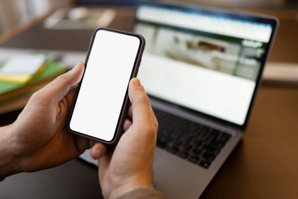 istock Man hand holding smartphone using mobile app shopping online, looking at blank display. Mockup 1699271977