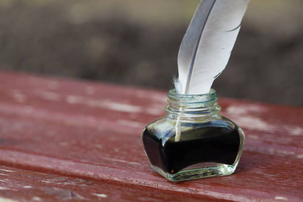 istock A vintage inkwell and a quill pen on wooden surface 1699275108