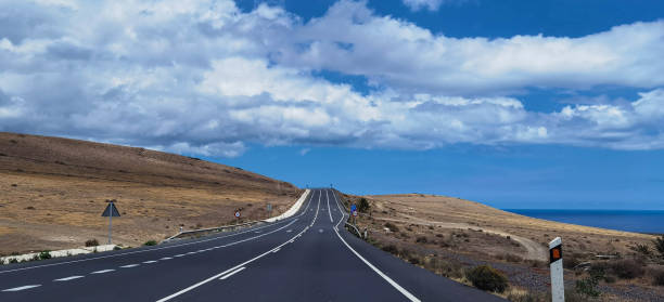 istock Volcanic Island Road with Ocean View, Lanzarote, Spain 1699284107