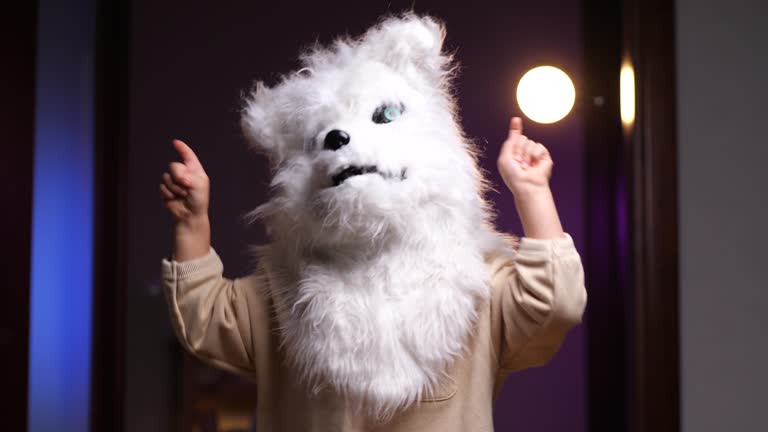 little child in a wolf dog mask dancing and having fun, halloween mask