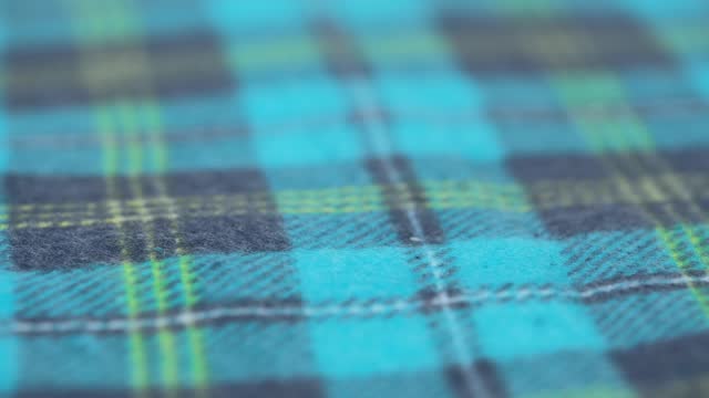 cozy flannel fabric with blue checkered pattern. closeup. slow rotation of soft cotton fabric. macro