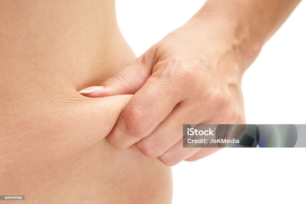 Love Handle Woman pinching her paunch. Isolated on a white background. Abdomen Stock Photo