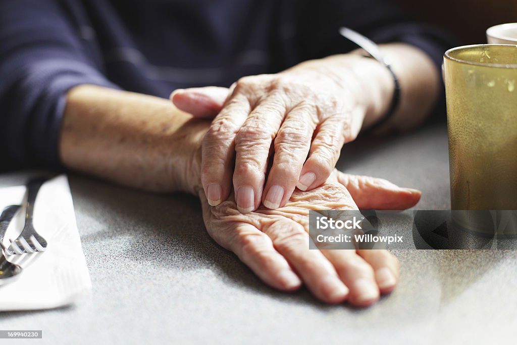 Senior donna con le mani sul tavolo del ristorante - Foto stock royalty-free di Terza età
