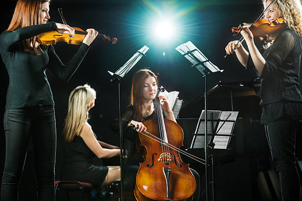 Female orchestra. Female quartet playing classical music.    musical instrument string stock pictures, royalty-free photos & images