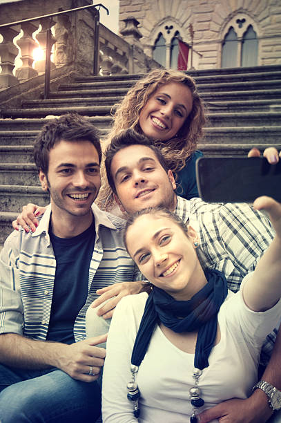 istock Four Happy friends Taking a Photo with Mobile Phone 169940733