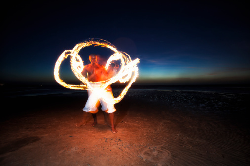 A member of a capoeira group dancing with a fire torch
