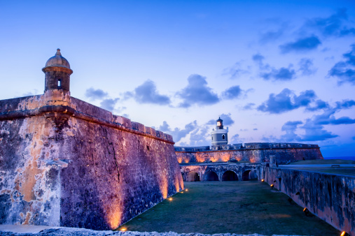 Tower and lighthouse at El Morro fort in San Juan, Puerto Rico lit up at night